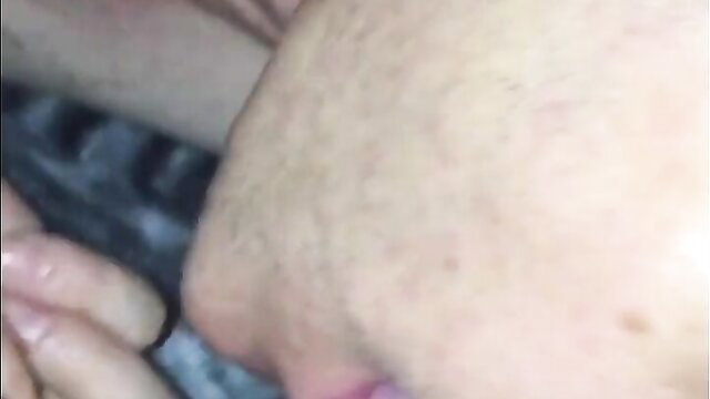Blurry closeup of bearded man's face and hand near woman's crotch in car