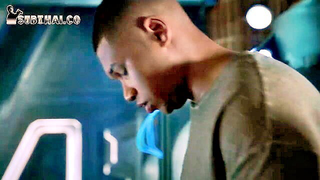 Handsome black man in gray tee, closeup profile in blue-lit scene