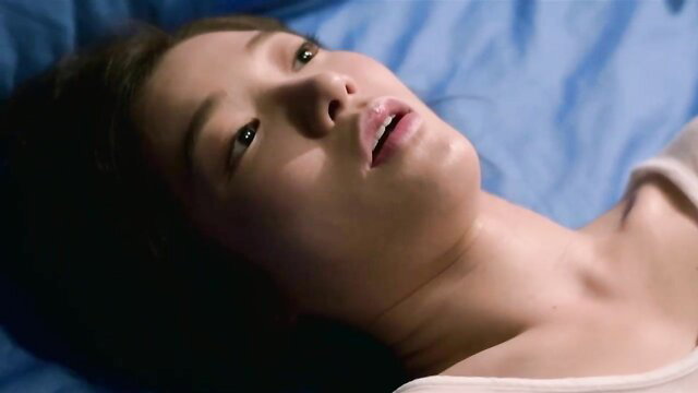Asian beauty in steamy K-movie sex scene, seductive gaze on blue sheets