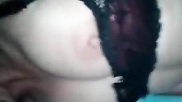 Closeup of woman's pale shaved pussy lips spread by black lingerie thong