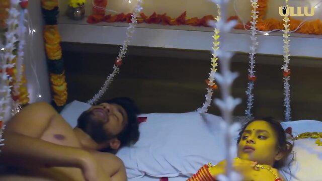 Indian wife in yellow bridal saree beside shirtless husband in bed, Ullu hot series