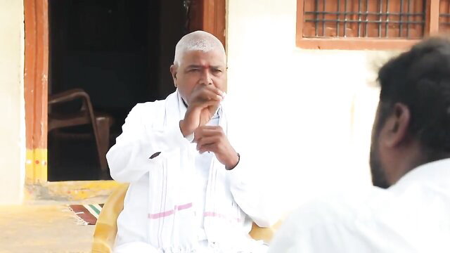 Elderly Indian man in white dhoti gesturing intimately, desi aunty style