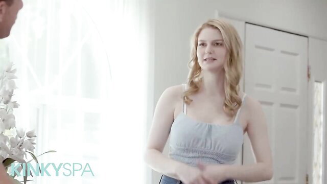 Irresistible blonde in tank top at Kinky Spa smiles seductively
