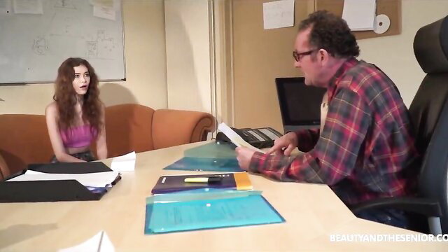 Katy Sky in pink top with older man in office interview