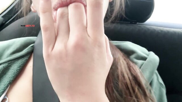Luna Lou makes rock on hand sign with lips pursed in car backseat