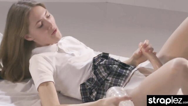Charming dorm girl in schoolgirl uniform jerks strapless dick till squirt