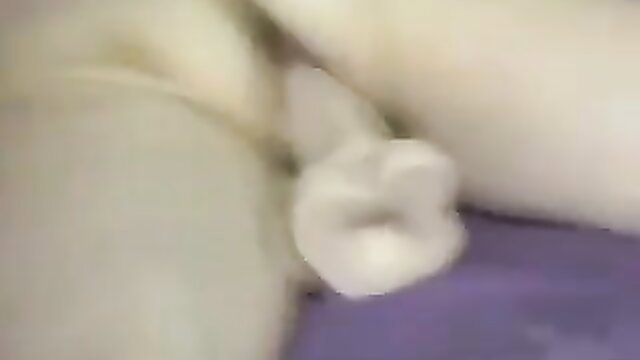 Blurry closeup of pale girl's plugged pussy and paw-shaped dildo
