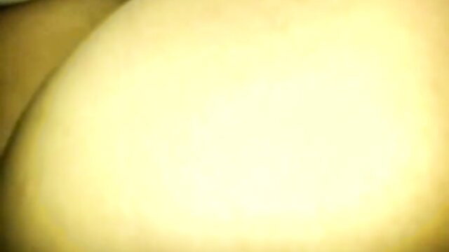 Blurry yellow-lit closeup of mature Korean ajumma's face in adult confession video