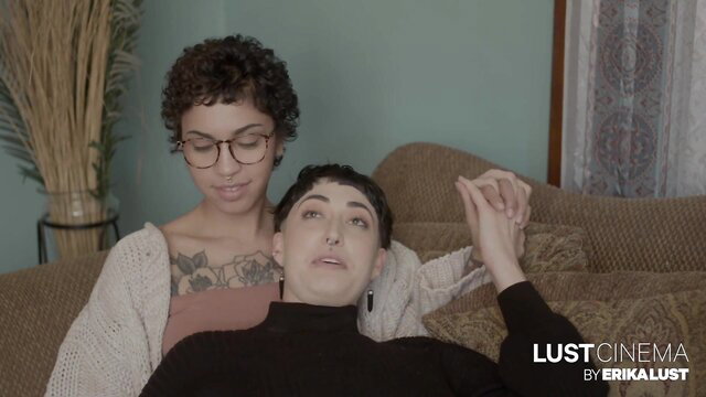 Ravyn Alexa holds hand of woman on couch in erotic Lust Cinema scene