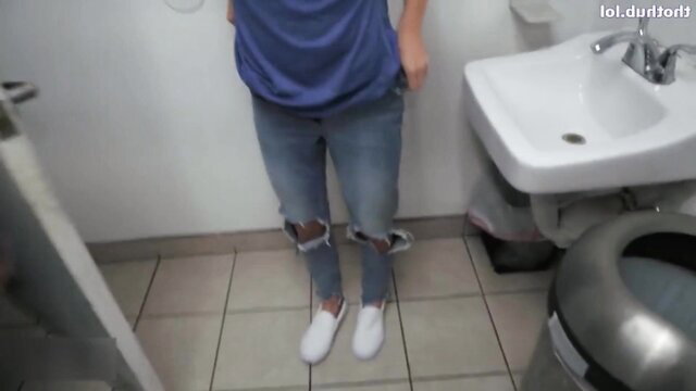 Guy in ripped jeans and blue shirt posing in bathroom at gamer center