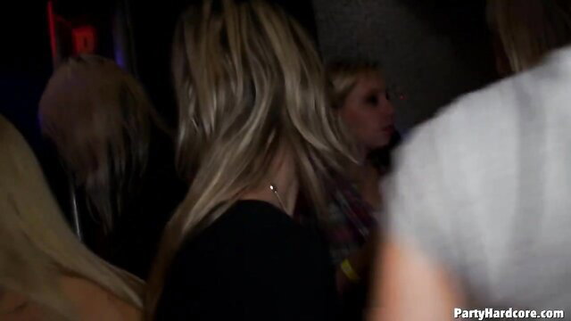 Blonde women partying at wild soiree in dim club lights