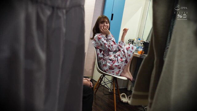 Asian beauty in floral dress sitting barefoot in dressing room