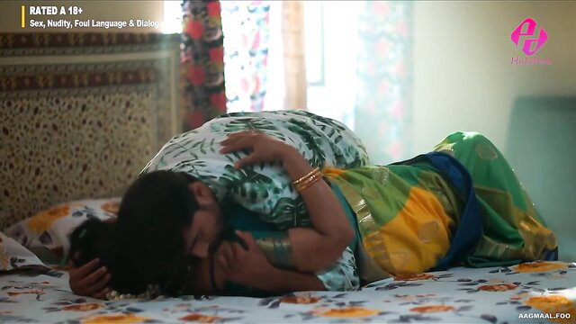 Indian woman in green saree lying seductively on bed in hot scene