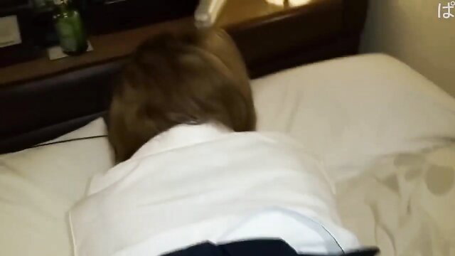 Asian amateur woman in white shirt and skirt lying face down on bed