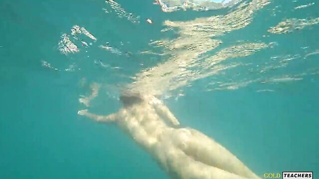 Nude model swims underwater nude on public Russian beach