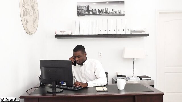 Black coworker in white shirt plowing hard at office desk