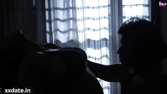 Silhouette of couple having sex near window with curtains