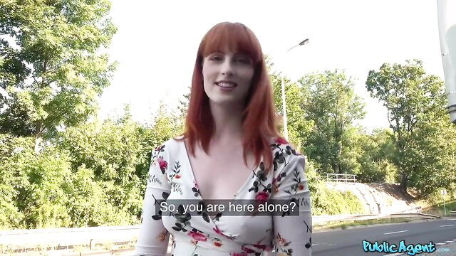 Redhead in floral dress standing outdoors