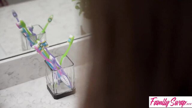 Colorful toothbrushes in bathroom cup from Family Swap orgy