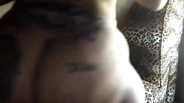 Tattooed ebony babe exposes huge booty and big tits in leopard dress