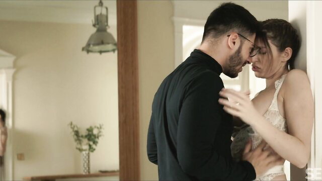 Passionate couple foreplay: man embraces brunette in lingerie