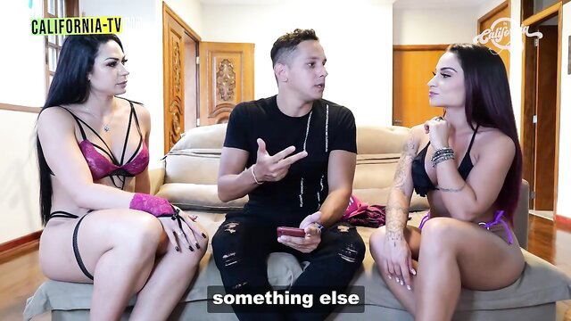 Two busty Brazilian babes in lingerie with TV host on couch