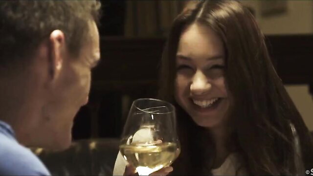 Taylor Sands smiling with wine glass in intimate date scene