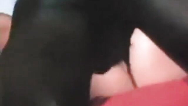 Vintage closeup of pale woman's large tits spilling from black bra on red