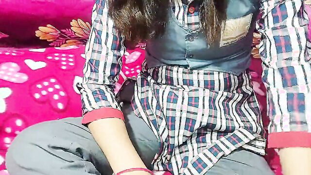 Indian college girl in plaid school uniform skirt on pink bed