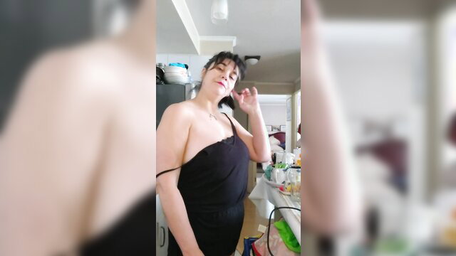 Curvy brunette mommy posing topless in sheer black dress in kitchen