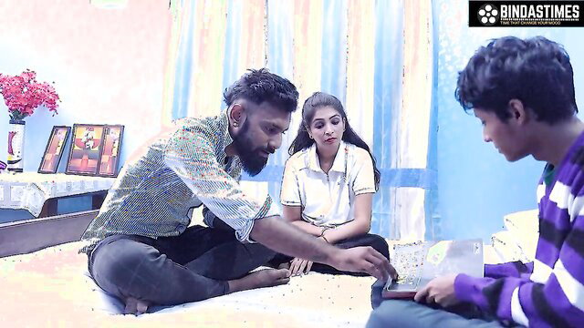 Indian teacher in white blouse with bearded student's dad, boy watches