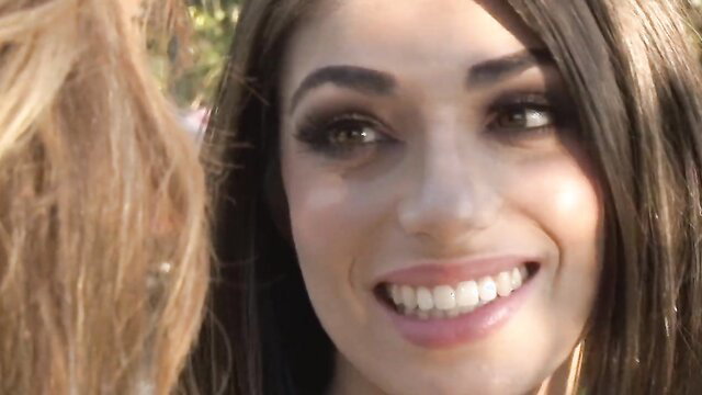 Darcie Dolce smiling seductively outdoors, big tits brunette beauty