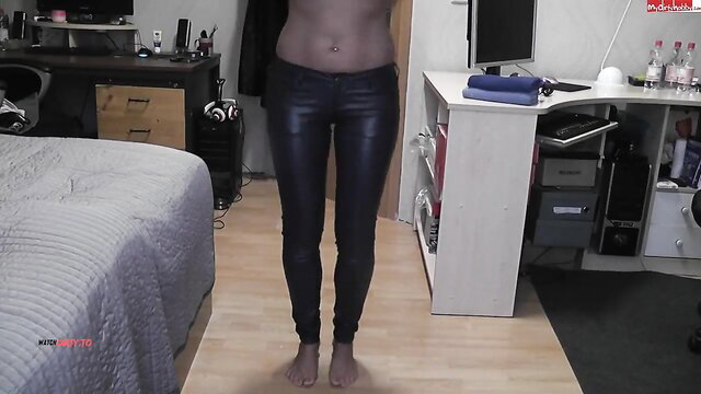 Red Phoenix poses in tight shiny black leather pants, bare midriff