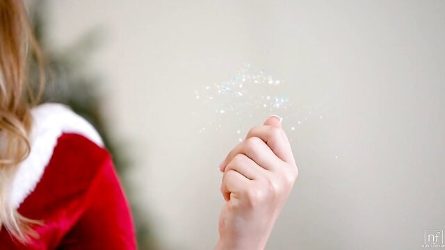 Blonde Santa girl with magical sparkles in sexy holiday lingerie