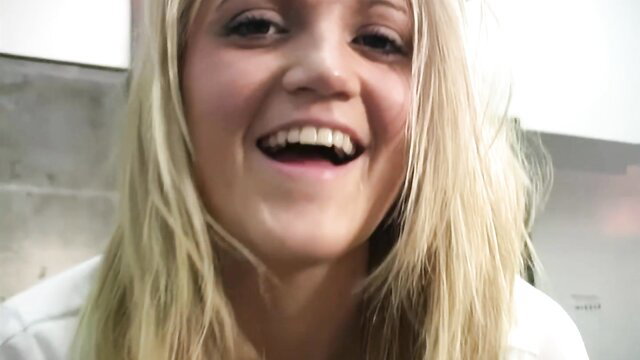 Smiling blonde teen girl with pretty eyes laughing in closeup