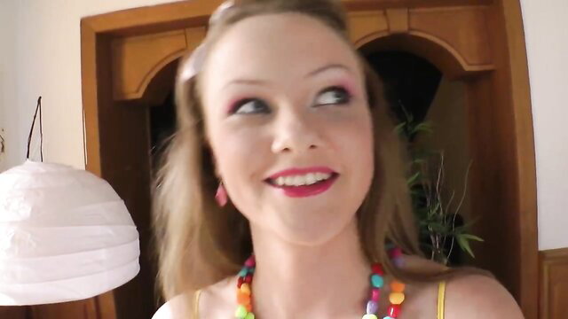 Blonde bombshell with colorful beads smiling seductively in solo tease