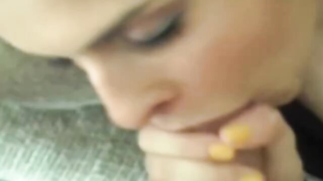 Blonde woman in closeup with hand near mouth, teasing oral pleasure