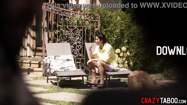 Lexi Luna in yellow top and shorts on lounge chair outdoor