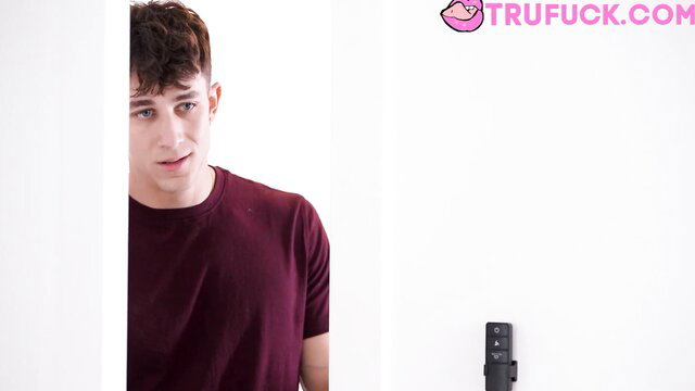 Cute curly-haired twink in tight maroon tee peeks shyly from TRUFUCK ad
