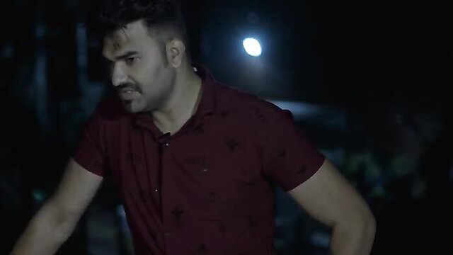 Handsome Indian man in tight maroon shirt, intense night gaze