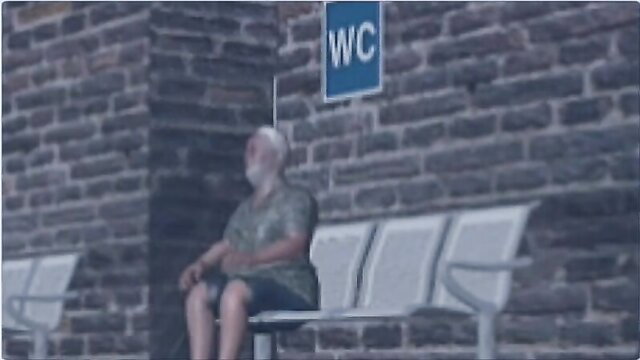 Elderly white bear daddy sits by public bathroom WC sign, cruising gay vibes