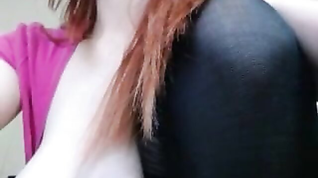 Redhead in pink T-shirt teases big tits, black leggings pulled down