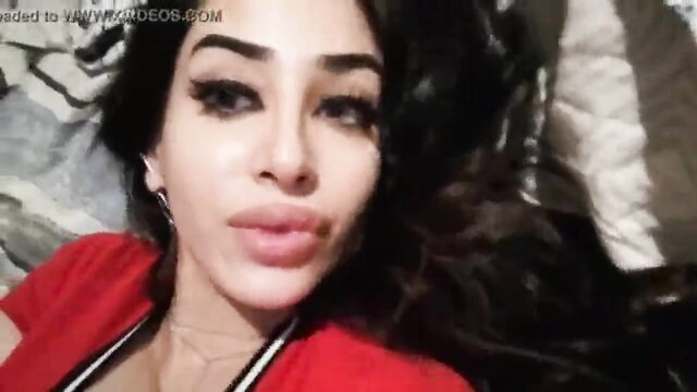 Arab beauty with bold makeup lying in bed, teasing lips