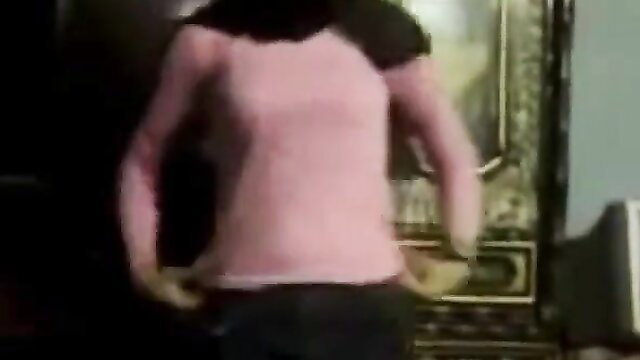 Arab woman in pink top and black pants dancing seductively