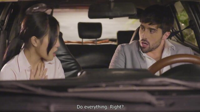 Asian beauty in white blouse chats with handsome man in car, tense moment