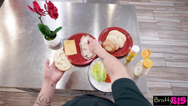 Chloe Temple making a sandwich with a tattooed hand