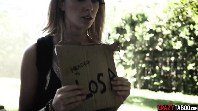 Haley Reed holds 'Heads to Losa' sign outdoors in tight top