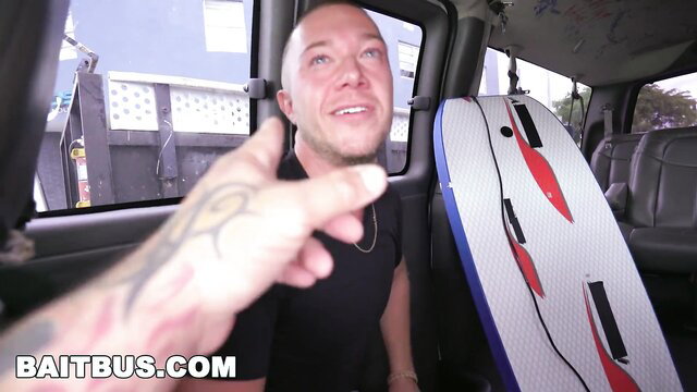 Bald tattooed white guy in Bait Bus points seductively at str8 dude bait