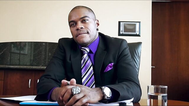 Handsome bald Black man in suit smirks in office, Lust Cinema XXX