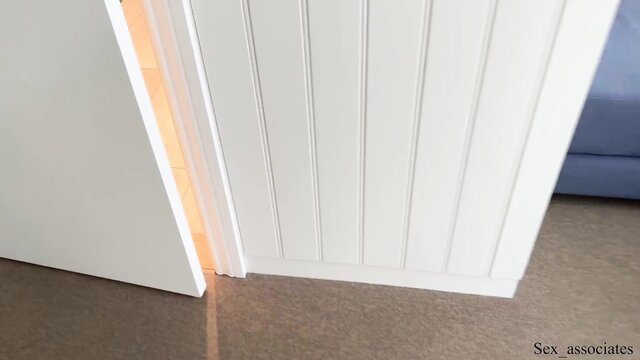 Stepmom in white paneled door with warm light glow, taboo tease